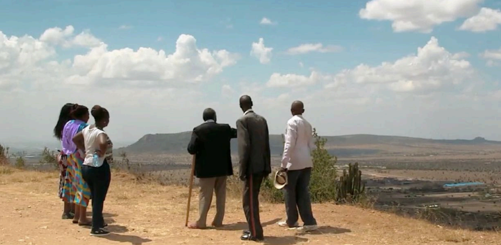 A group of people looking out on a mountain top in Kenya.